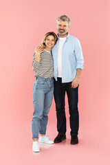Loving Middle Aged Couple Embracing Standing Over Pink Background