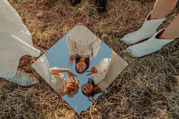 VIEW FROM ABOVE. GIRLS REFLECTED IN A MIRROR. 