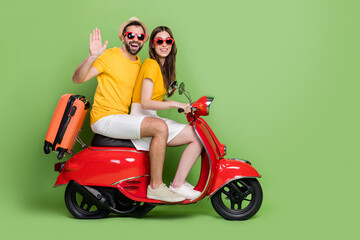 Fototapeta na wymiar Full body profile photo of handsome guy attractive lady drive bike arm palm waving isolated on green color background