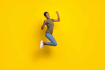 Fototapeta na wymiar Full size portrait of delighted person jump raise fists celebrate triumph isolated on yellow color background