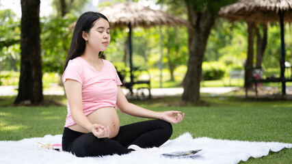 Pregnant woman touching belly in the City Park, Pregnant Relaxing and exercise, Beautiful tender mood photo of pregnancy