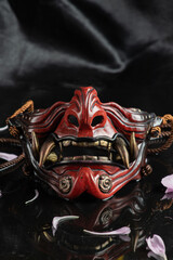 photo on a dark background of a samurai mask in the form of a demon mask