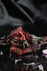 photo on a dark background of a samurai mask in the form of a demon mask
