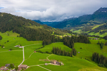 Fototapeta na wymiar Aerial view of fields and landscape with mountains in the center of Switzerland in the Berner Oberland