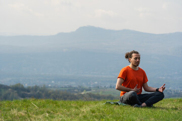 Fototapeta na wymiar Man sitting on the mountain peak and telling something