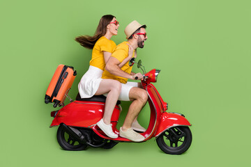 Fototapeta na wymiar Full size profile photo of two cheerful excited partners drive bike speed isolated on green color background
