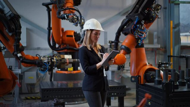 Female chief engineer in modern industrial factory using tablet.