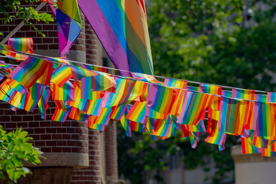 Celebration of pride month in Amsterdam, Rainbow flag hanging outside building along street, Symbol of Gay, Lesbian, Bisexual and Transgender, LGBT community in Holland, Social movements, Netherlands.
