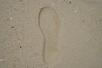 Fototapeta na wymiar Shoe prints on sandy beach