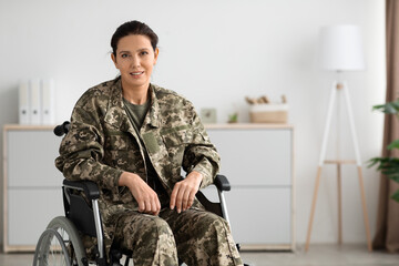 Portrait Of Smiling Female Soldier In Camouflage Uniform Sitting In Wheelchair Indoors
