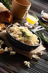 Popcorn  in cast iron skillet with paper bucket and melted butter aside