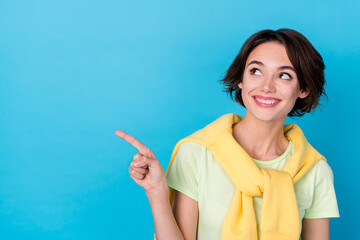 Photo of dreamy sweet lady dressed yellow pullover pointing finger looking empty space isolated blue color background