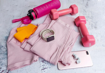 Fitness set with female clothing, dumbbells , bottle of water ,elastic band ,smartwatch and smartphone