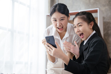 Business women happy and cheerful for successful on project via mobile phone in office space.
