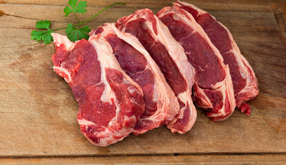 five raw steaks of sirloin beef. top grade premium quality meat on wooden cutting board
