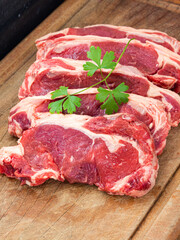 five raw steaks of sirloin beef. top grade premium quality meat on wooden cutting board, vetical shot.
