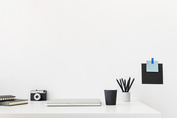 Home office, creative desk with office supplies and beige wall.