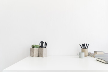 Office table, empty desk with supplies and white wall copy space.	
