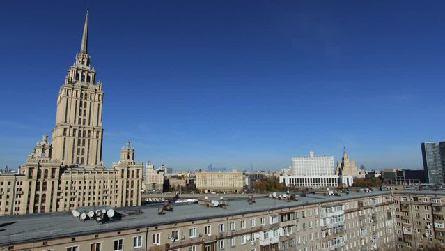 Time lapse view of the a seven sister building in moscow and the white house in front of a blue sky.