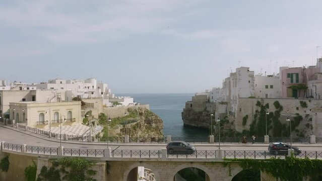 Aerial footage flying over a bridge and over Lama Monachile towards the sea in Polignano a Mare, Italy.