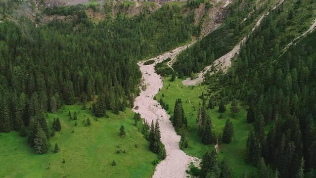 Aerial view above dense woodland forest trail on valley slope of South Tyrol Plose Peitlerkofel mountain