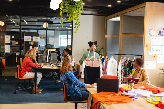 Multiracial male and female fashion designers working in office studio