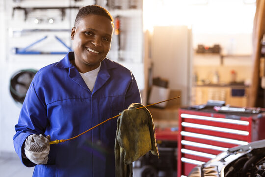 Portrait of smiling mid adult african american female mechanic working in workshop, copy space