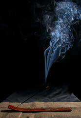 indian incense stick with smoke on black background