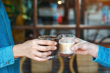 Close up of young couple hands clinking or toasting glasses of coffee talking sharing showing love and care, support, and Cheers, or business dealing, leisure time with friends idea. For Copy Space