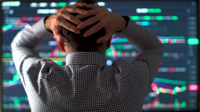 Frustrated trader holding head with hands watching the market crash