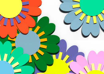 Pattern of paper flowers of different colors on a white background.
