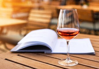 A glass with aperol on the table in a summer street cafe. Relaxation and enjoyment. Close-up. Place for text. Selective focus.