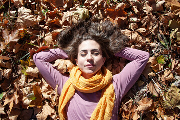 Chica relajada tirada en la hierba en otoño.