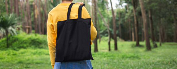 woman holding black cotton bag in nature background