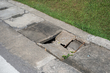 Damage manhole cover footpath and road. Manhole cement damage on street urban city. Damage cement gutter cover dangerous place at the town.