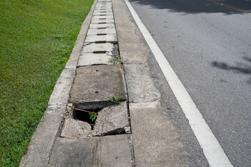 Obraz premium Damage manhole cover footpath and road. Manhole cement damage on street urban city. Damage cement gutter cover dangerous place at the town.