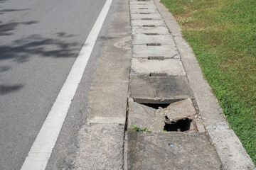 Damage manhole cover footpath and road. Manhole cement damage on street urban city. Damage cement gutter cover dangerous place at the town.