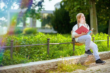 pensive school girl in sweatshirt outdoors in city