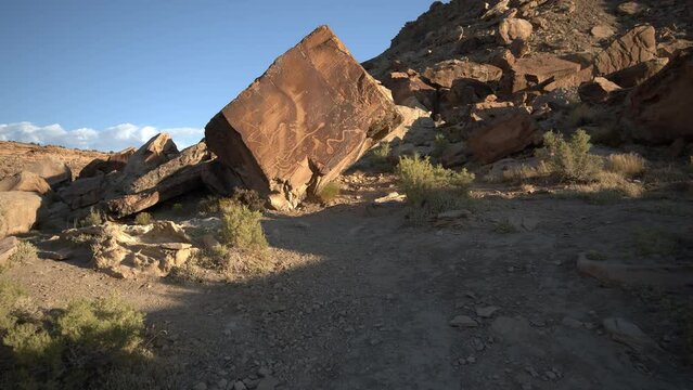 Hiking in the desert up to boulder with petroglyph in Dry Wash in Utah.