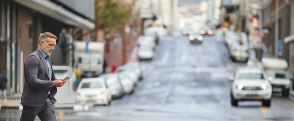 Theres no way they just said that. Shot of a handsome businessman walking through the city while using his smartphone.