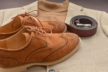 Men brown suede brogue shoes combined with light beige blazer and sweater. Top view.