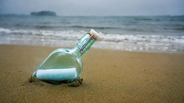 Bottle on beach with message on paper inside