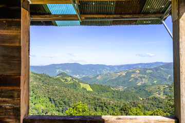 Beautiful mountain with meadow and forest by seeing through the wooden window in the local house