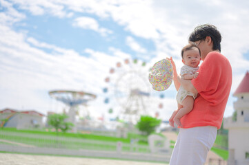 笑顔の親子と遊園地の外観