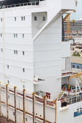Cargo ship moored in Shipyard during maintenance, cargo hold with Accommodation deck, navigation bridge deck and mast of radar antenna radio of ship on blue sky background. © AJITH.A