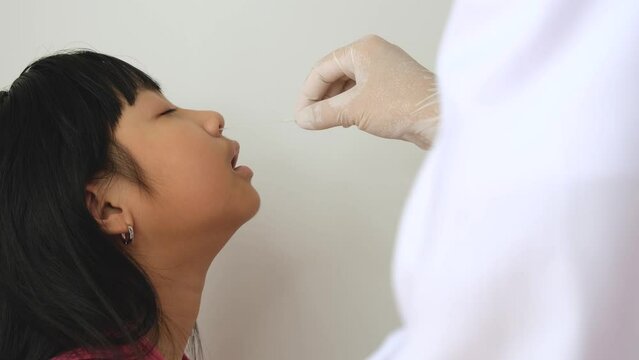 Healthcare workers are testing COVID-19 RAPID SARS-COV2 Antigen Test Kit (ATK) Nasal Swap or PCR for Asian girls.