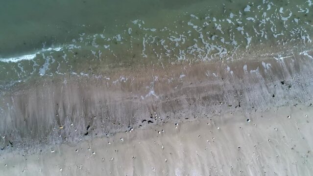 DRONE VIEW OF A BEACH IN LA MANCHE IN FRANCE
Static drone view of a beach in La Manche with sand and waves in spring. June 2022. Normandy, France.