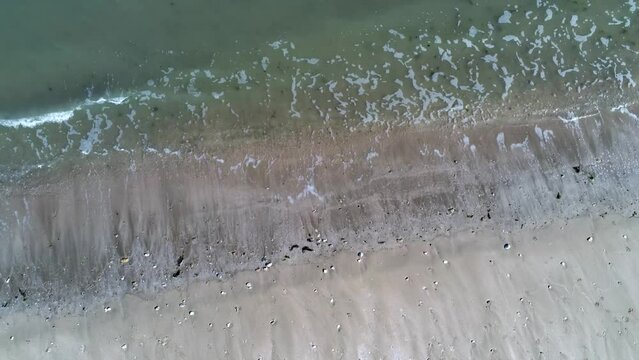 DRONE VIEW OF A BEACH IN LA MANCHE IN FRANCE
Static drone view of a beach in La Manche with sand and waves in spring. June 2022. Normandy, France.