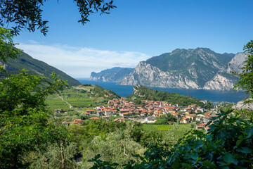 Fototapeta na wymiar view of Lake Garda and the village of Nago, vineyards and mountains on a sunny summer morning