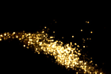 Golden blurred bokeh lights on black background. Glitter sparkle stars for celebrate. Overlay for your design